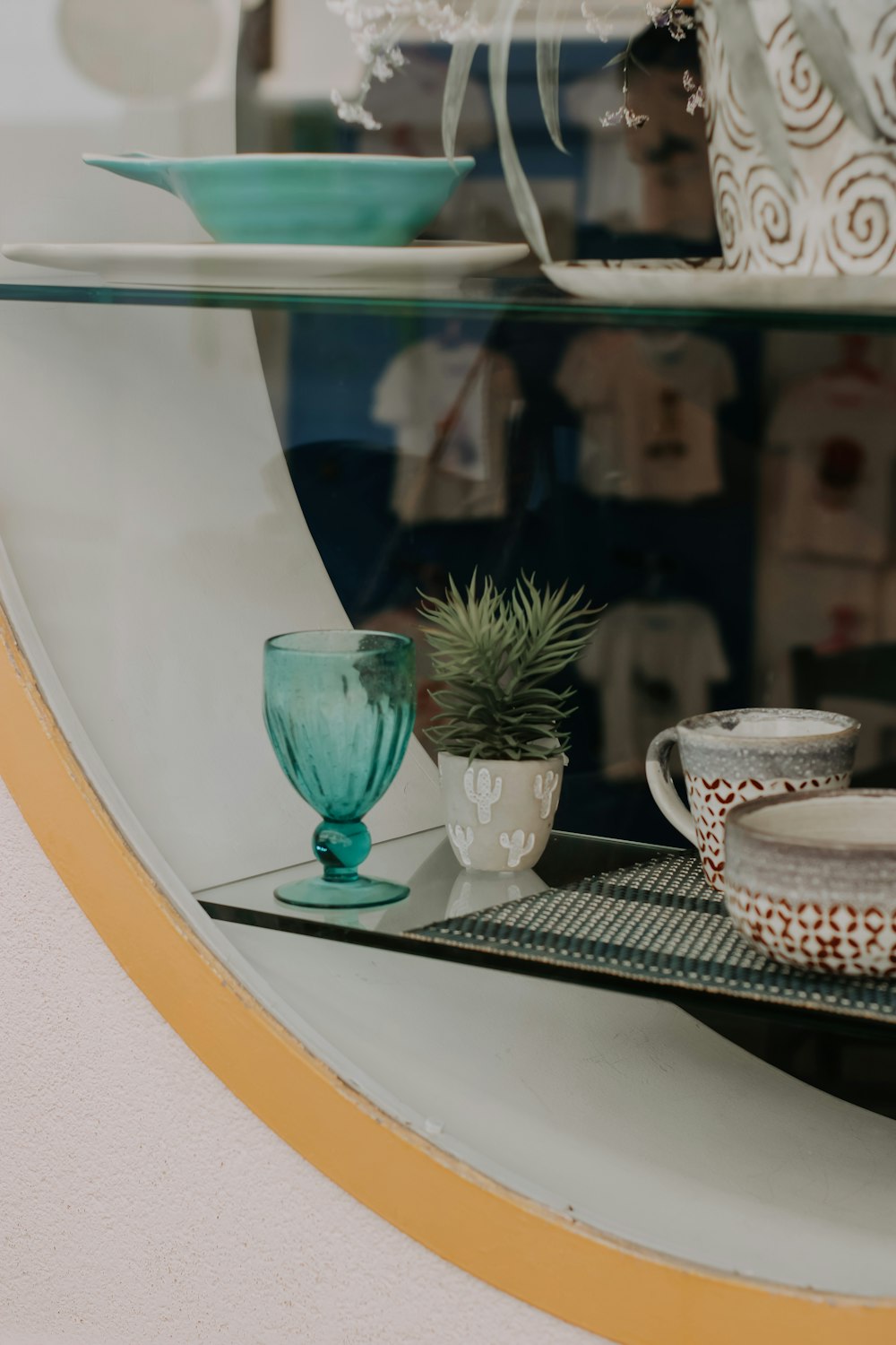 a shelf that has some cups and bowls on it