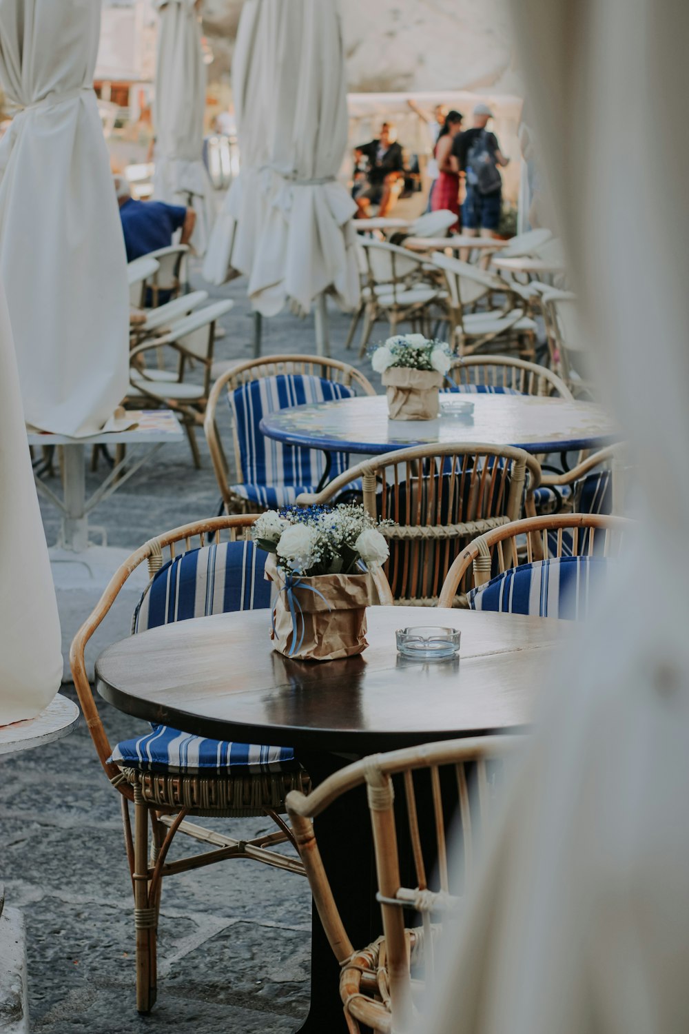 tables and chairs with umbrellas in the background
