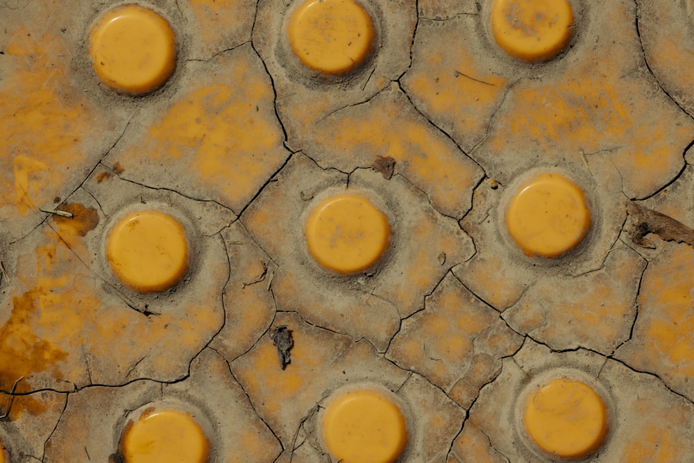 a close up of a cracked surface with yellow circles
