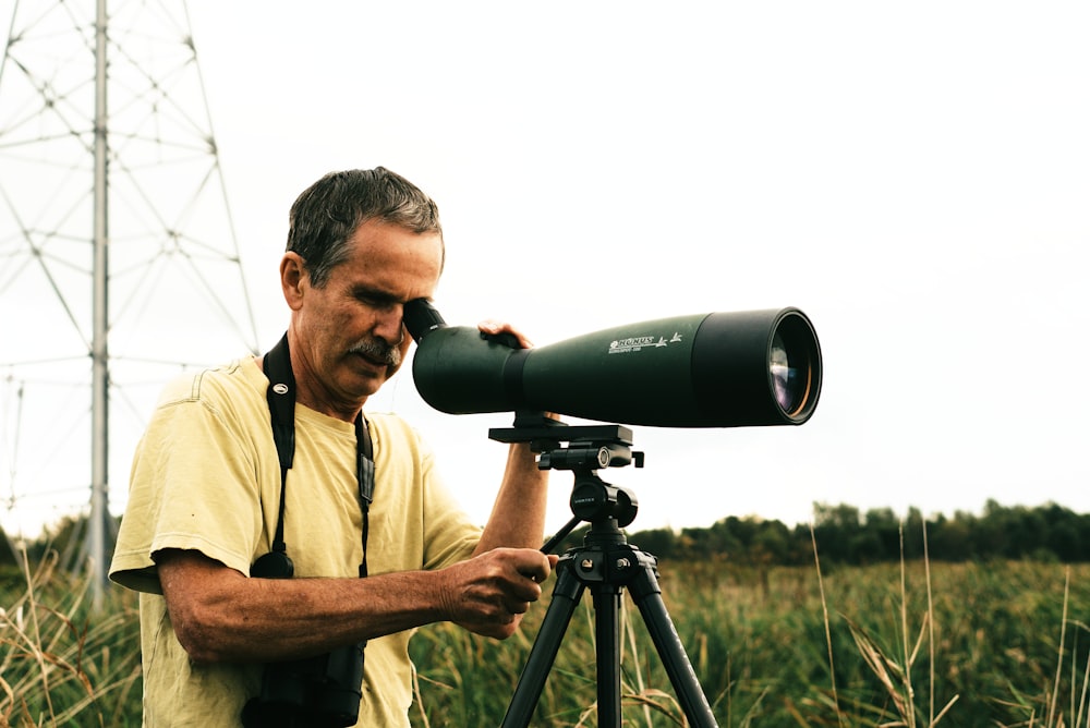 Un uomo che guarda attraverso un telescopio in lontananza
