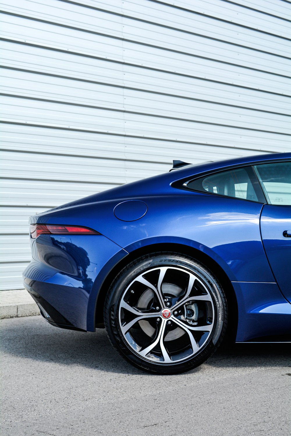 a blue sports car parked in front of a building