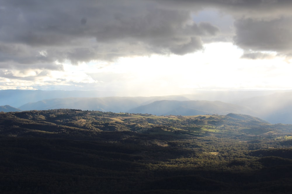 the sun shines through the clouds over the mountains