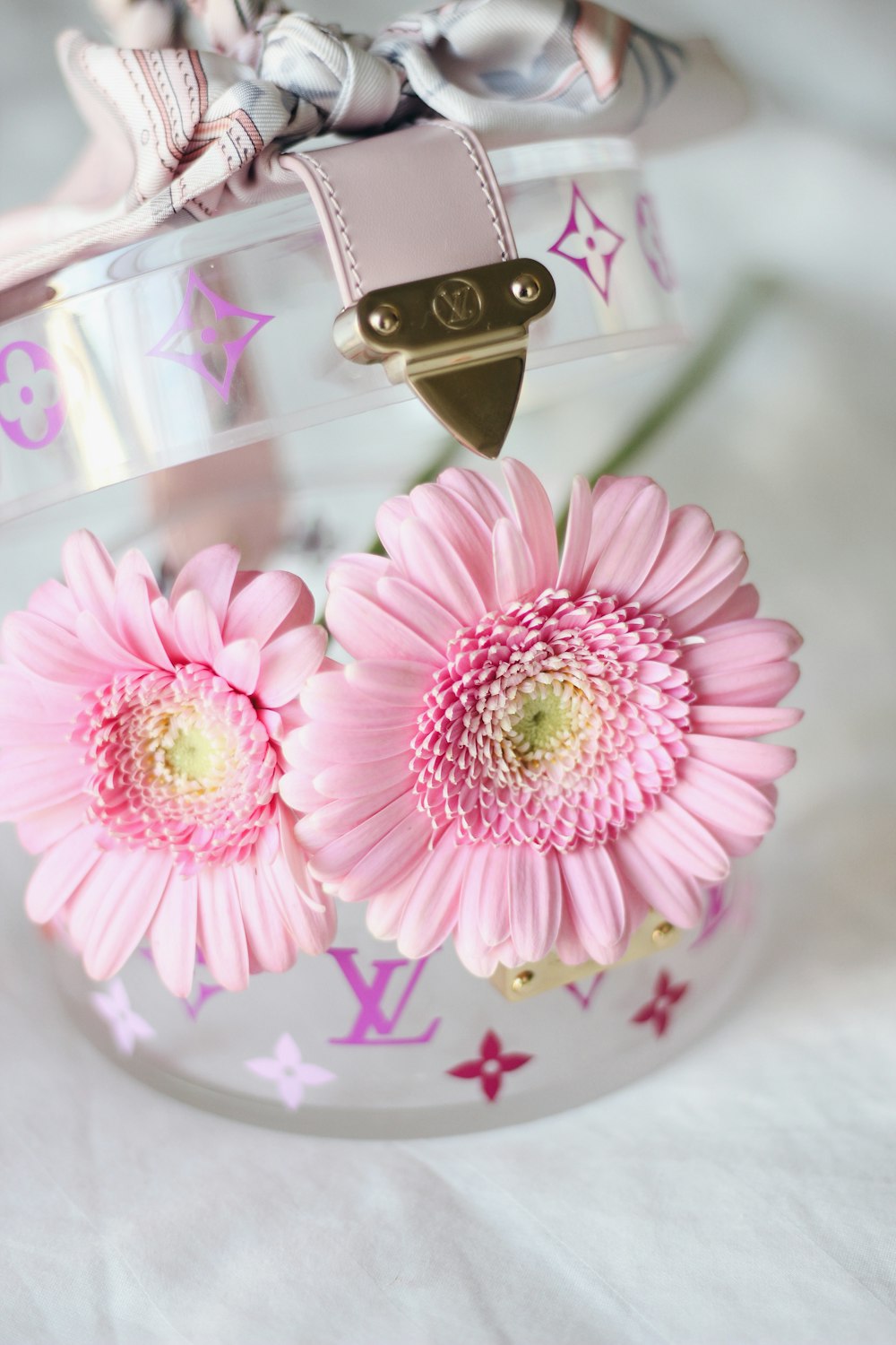 two pink flowers are in a clear vase