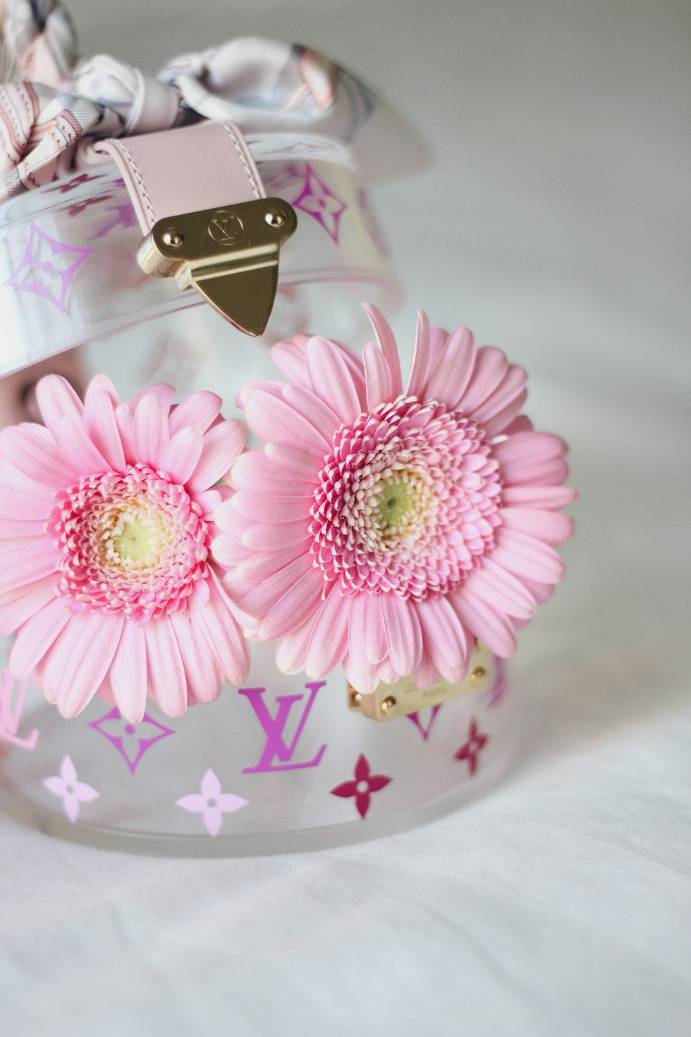 a pink flower sitting on top of a clear container