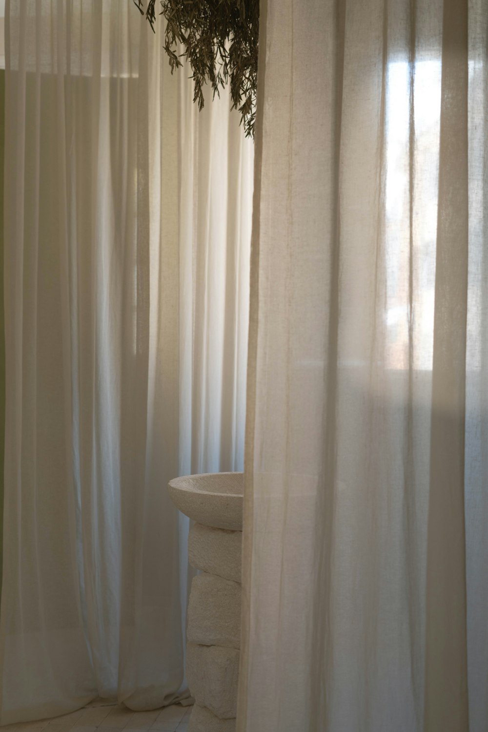 a bathroom with a sink and a curtained window