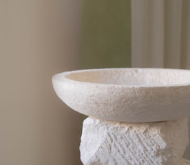 a close up of a white bowl on a table