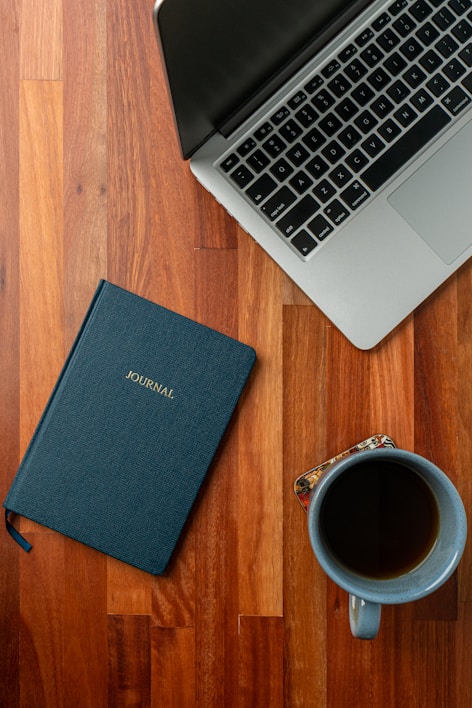 A colorful flat lay of digital budget planners open on a laptop screen with a cup of coffee nearby.