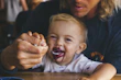 a woman feeding a child a spoon of food