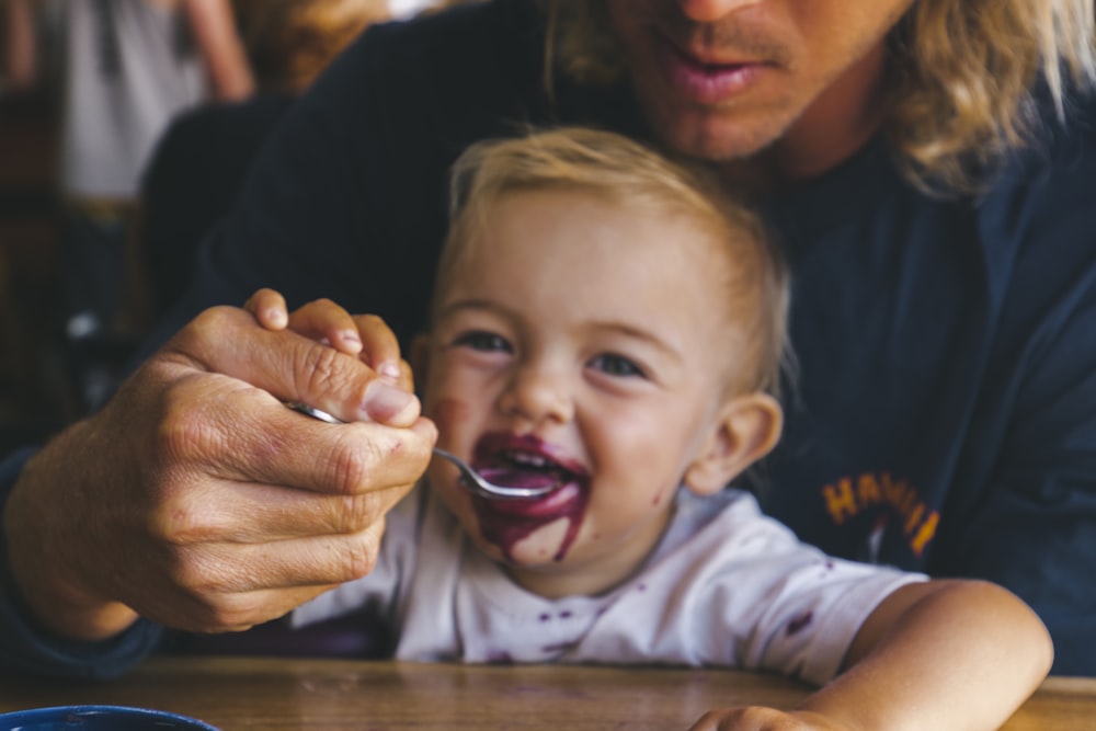 a woman feeding a child a spoon of food