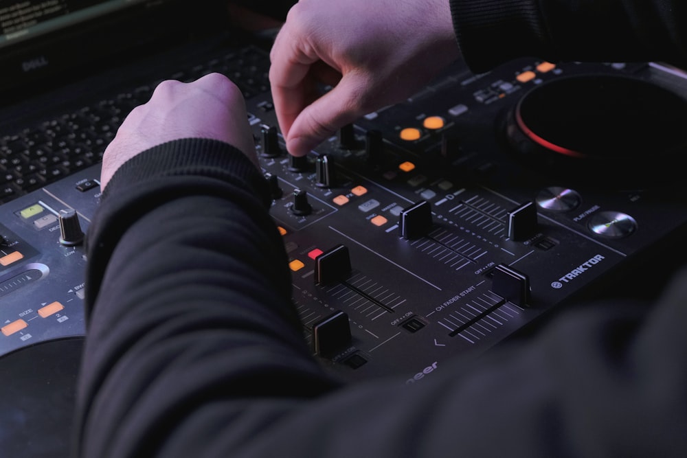 a person using a dj controller in front of a laptop