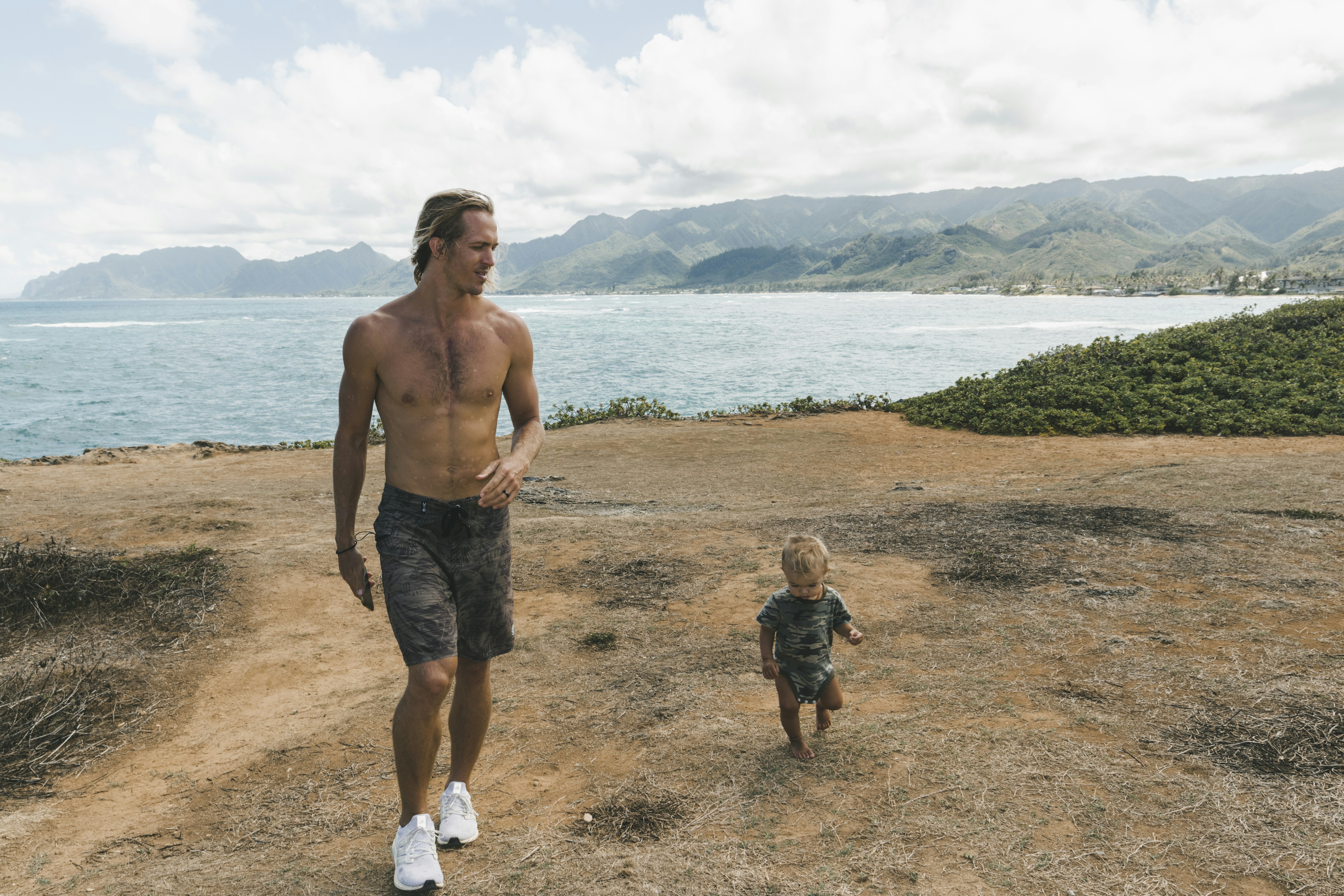 a man and a small child walking on a dirt road