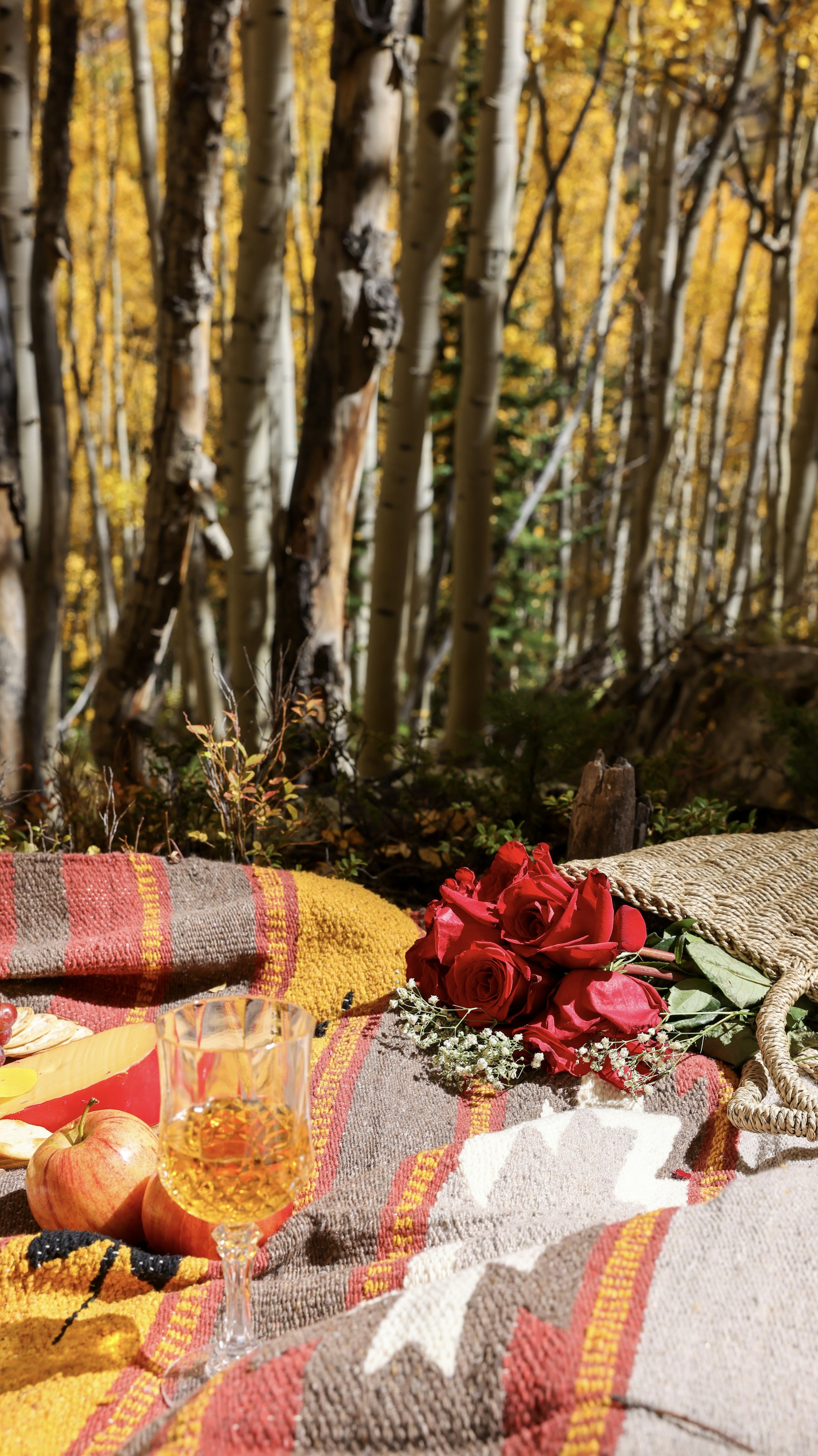A cozy family picnic under a large oak tree with children playing and adults chatting nearby.
