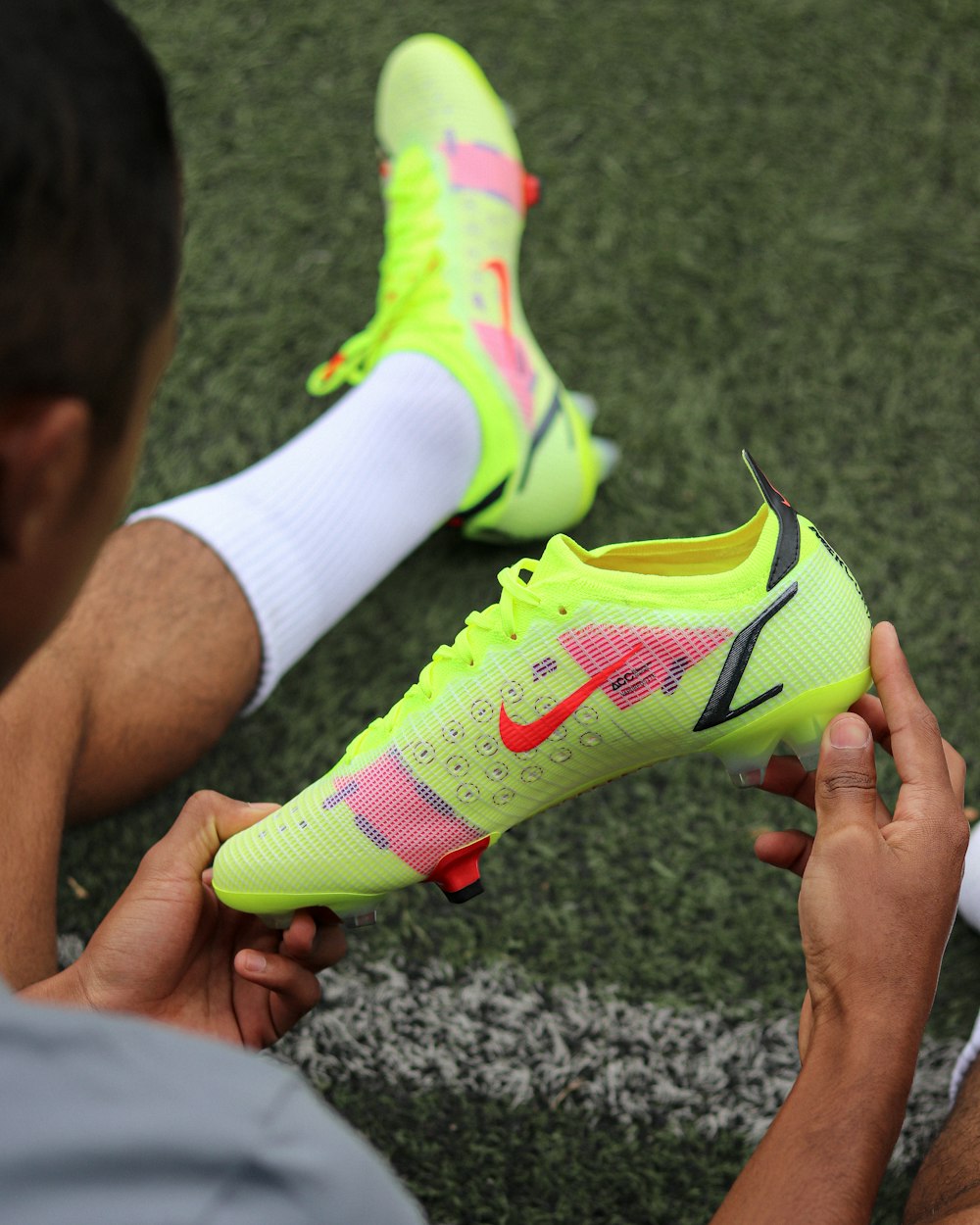 a man holding a pair of neon green shoes