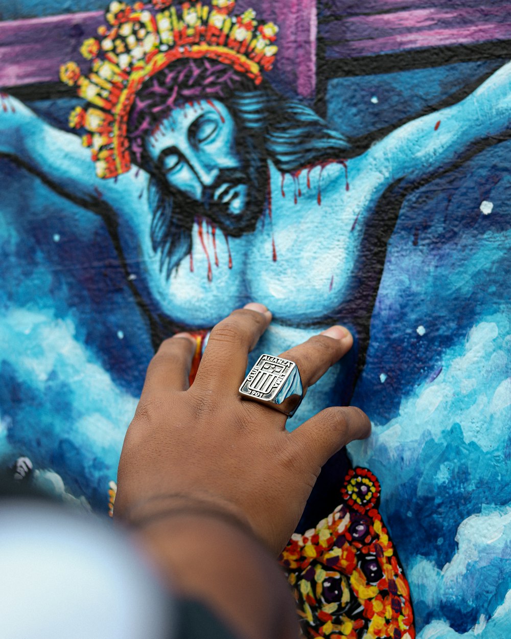 a man is painting a picture of jesus on a wall