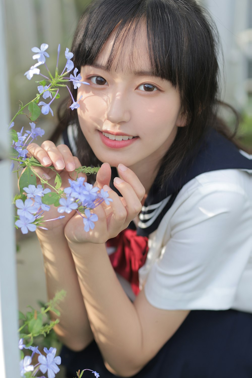 a woman holding a bunch of blue flowers