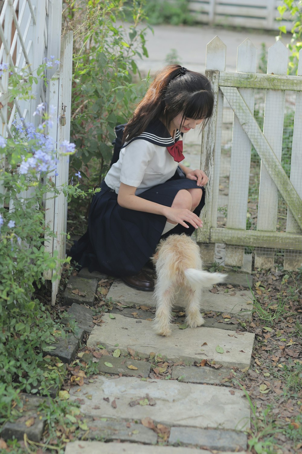 a little girl kneeling down next to a dog