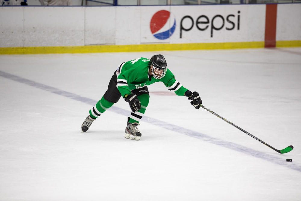 a hockey player in a green uniform is skating on the ice