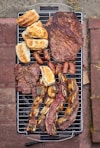 a bbq grill with a variety of meats on it