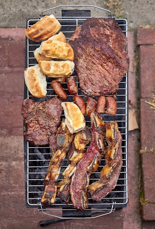 a bbq grill with a variety of meats on it
