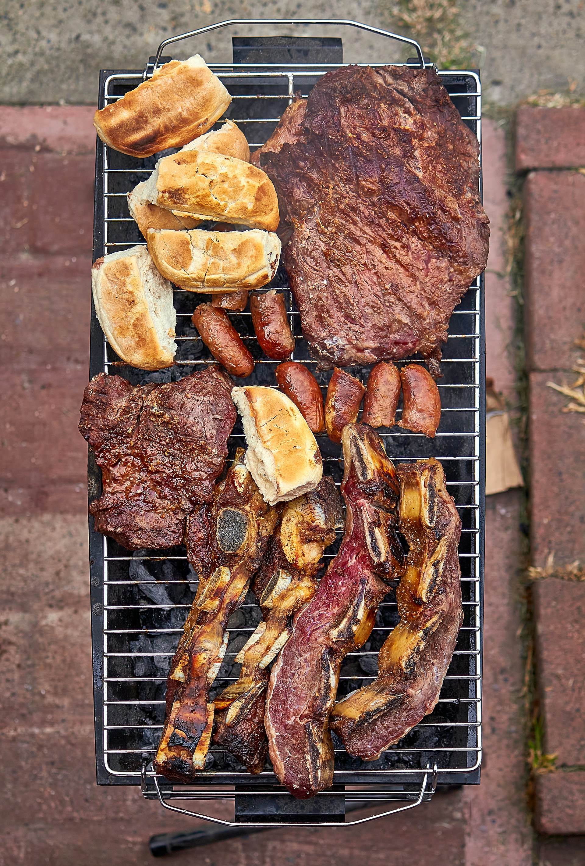 a bbq grill with a variety of meats on it