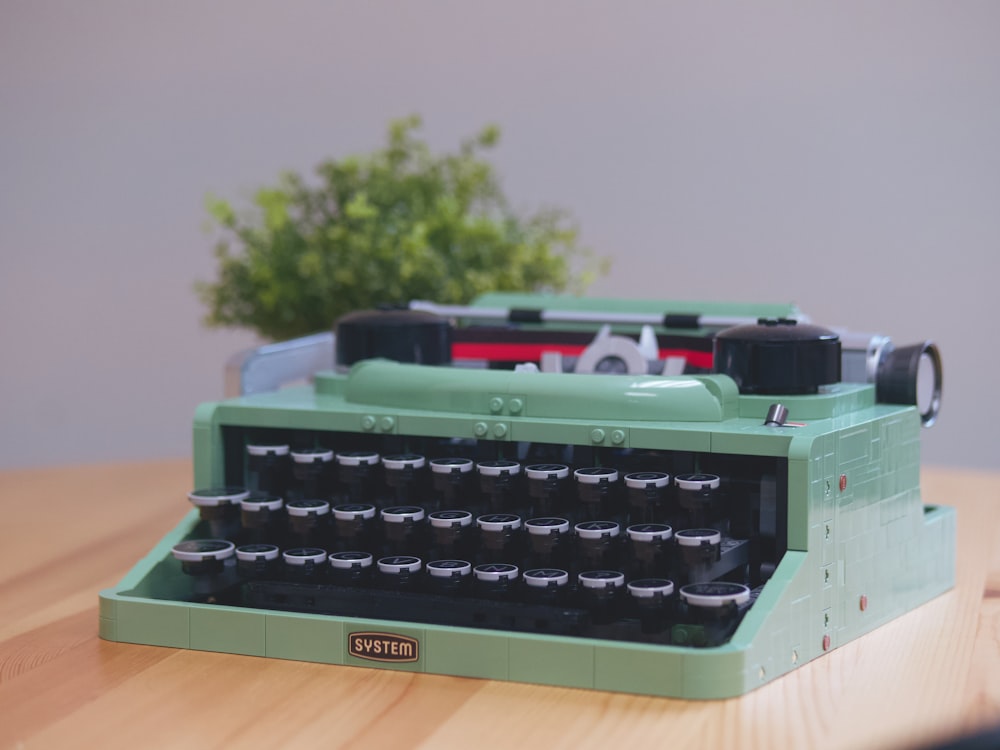 a green typewriter sitting on top of a wooden table