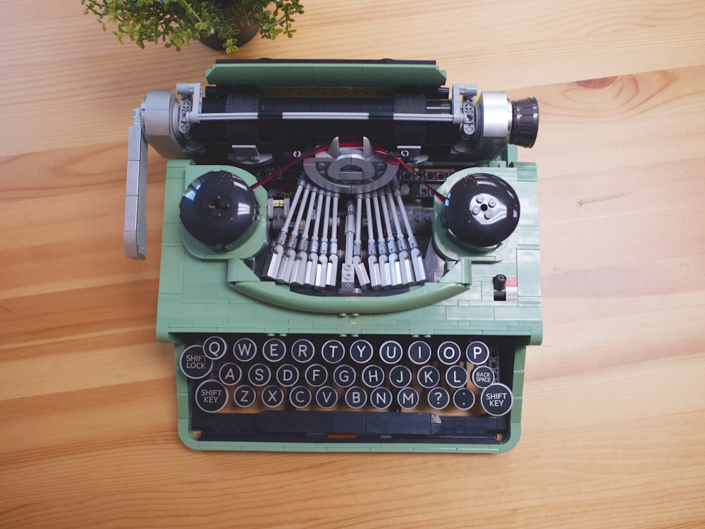 a green typewriter sitting on top of a wooden table