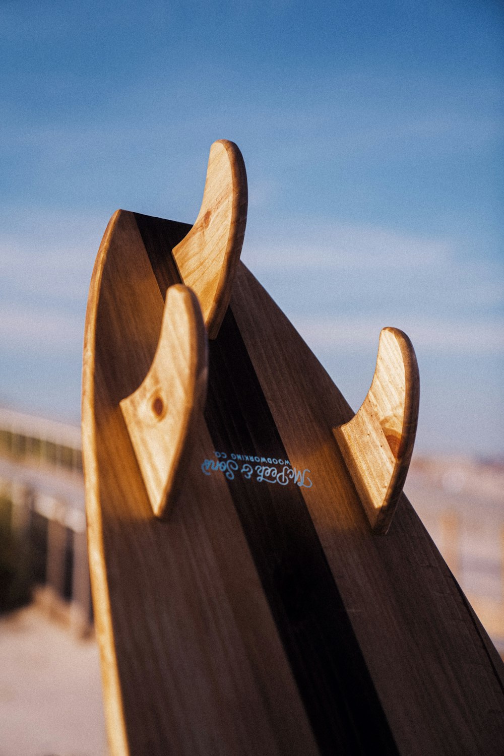 a close up of a wooden surfboard on a beach