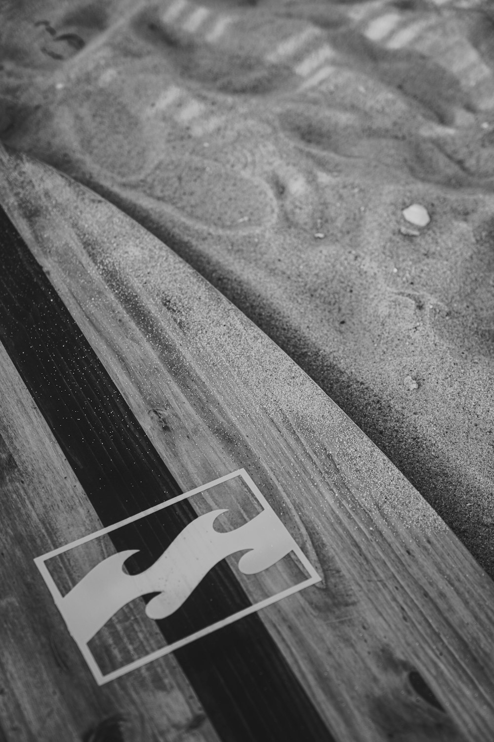 a close up of a surfboard laying on the sand