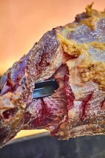 a piece of meat with a knife sticking out of it