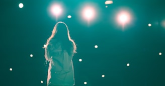 a woman standing in front of a green light