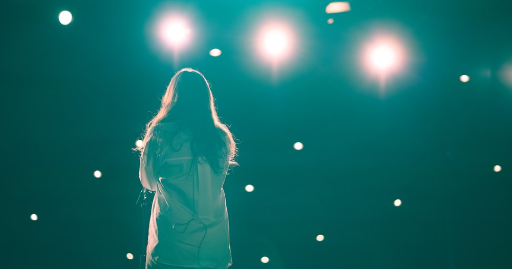 a woman standing in front of a green light