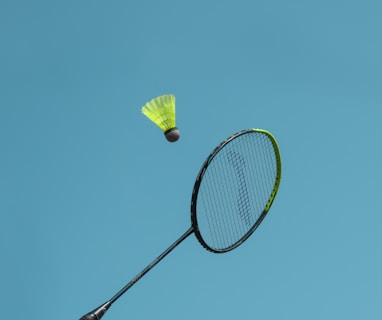 a badminton racket and a yellow frisbee flying in the air