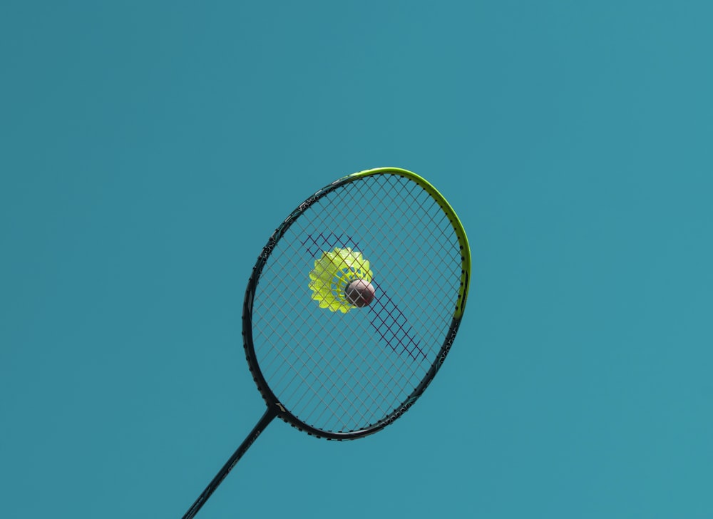 a close up of a tennis racket with a tennis ball on it