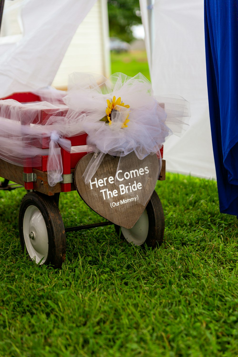 a red wagon with a flower on top of it