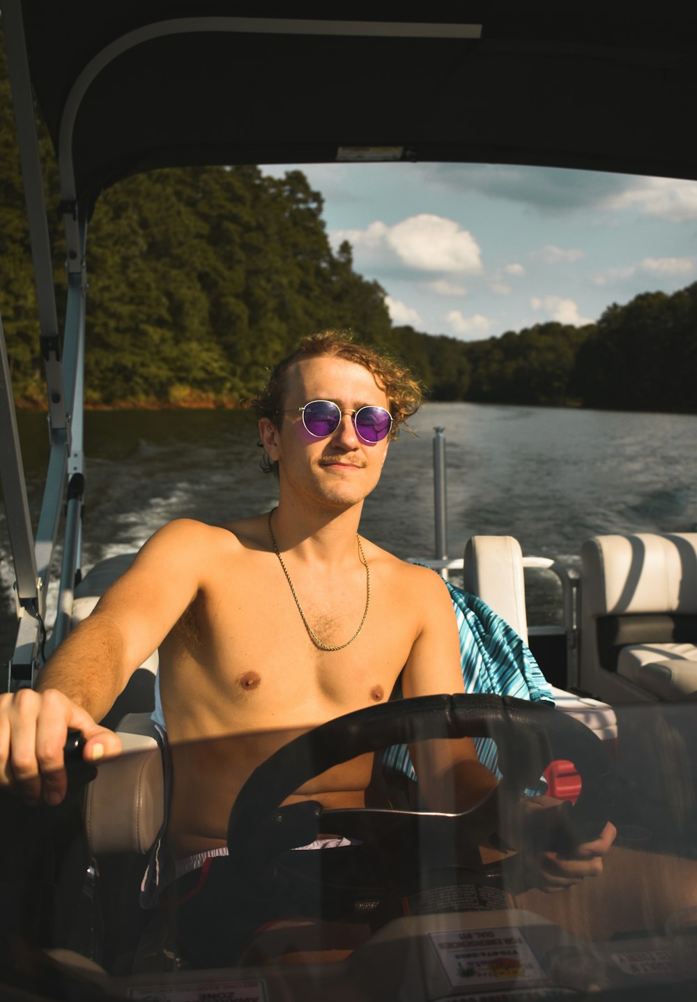 Un hombre sin camisa conduciendo un bote en un lago