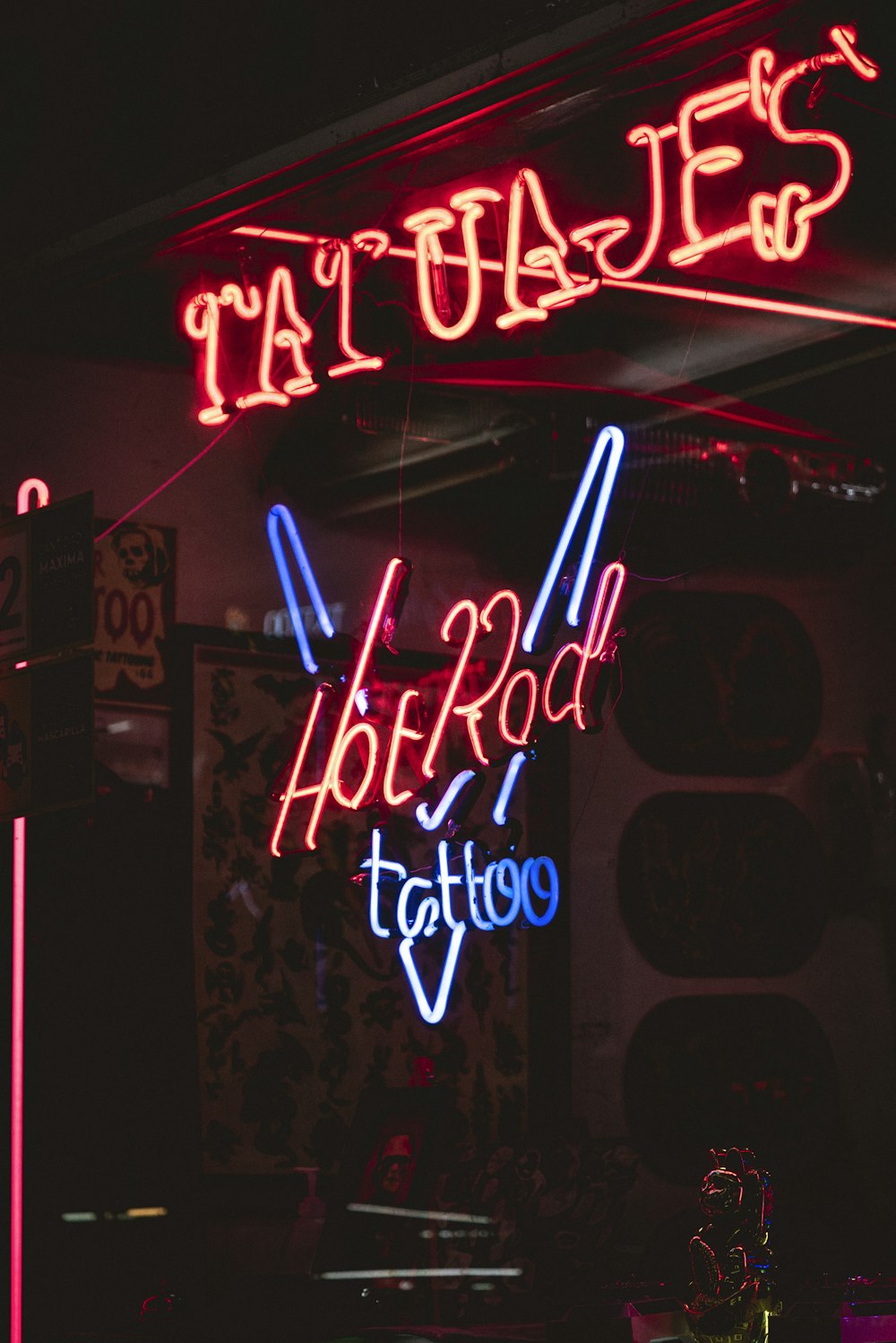a tattoo parlor with neon signs and neon lights