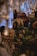 A collection of ornate ceramic sculptures depicting traditional Asian lion figures. The figures are intricately designed with detailed patterns and features, surrounded by other decorative objects. The setting appears to be a dimly lit room or shop, with a chandelier above adding to the ambiance.