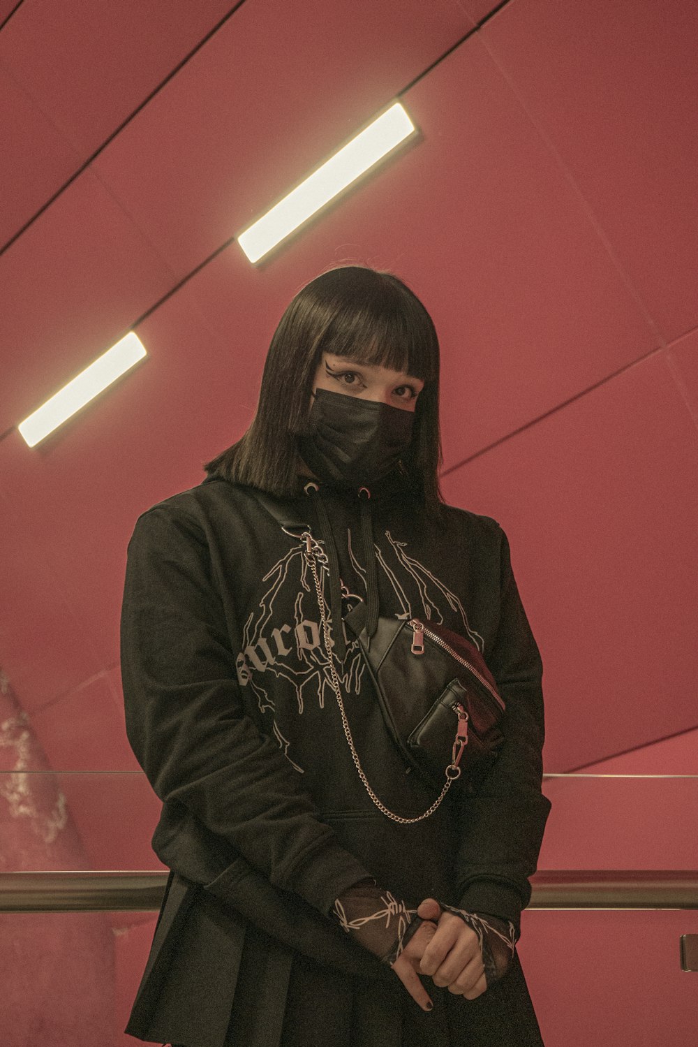 a woman wearing a black outfit and a black mask