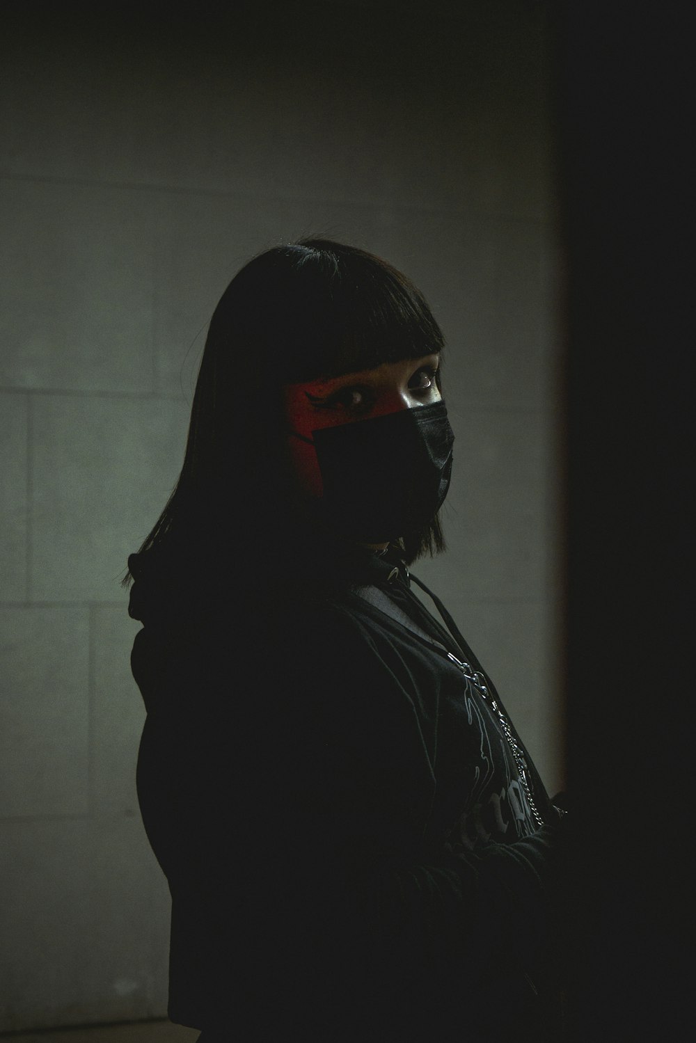 a woman wearing a mask and a black jacket
