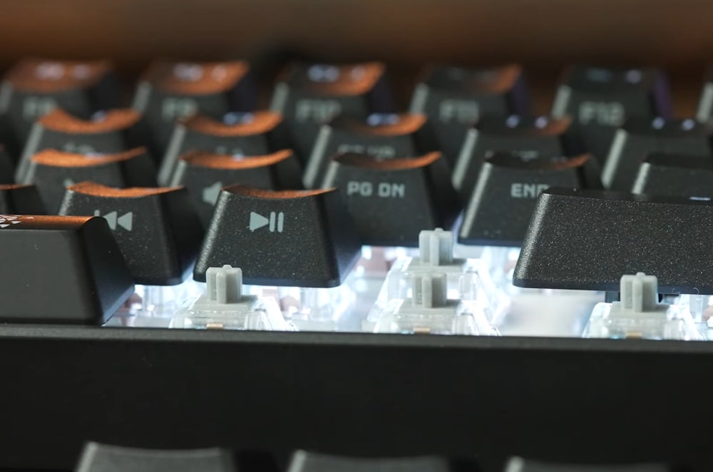 a close up of a computer keyboard with orange and black keys