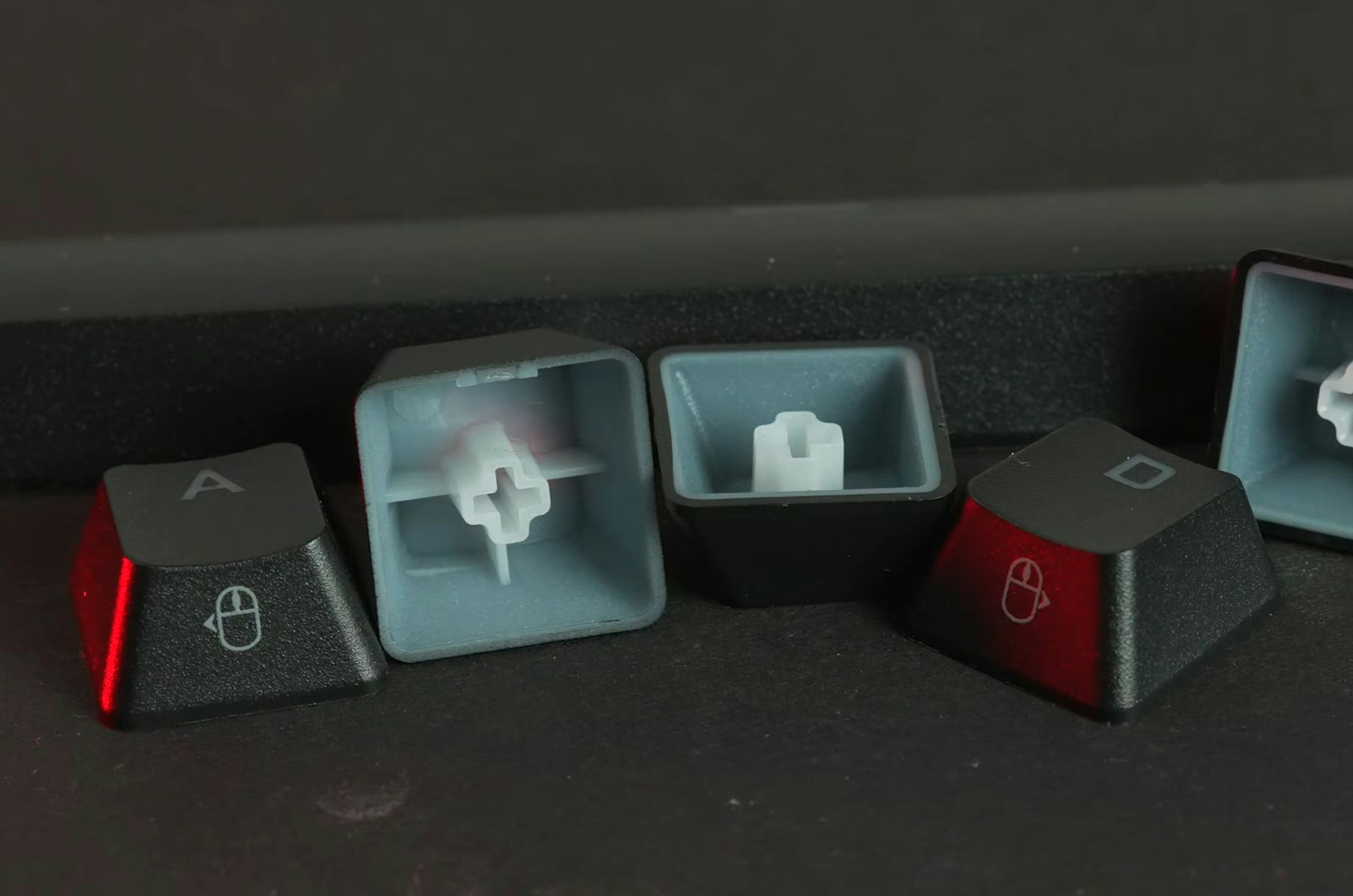 a set of three black and red computer keyboards