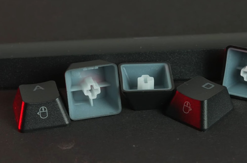a set of three black and red computer keyboards