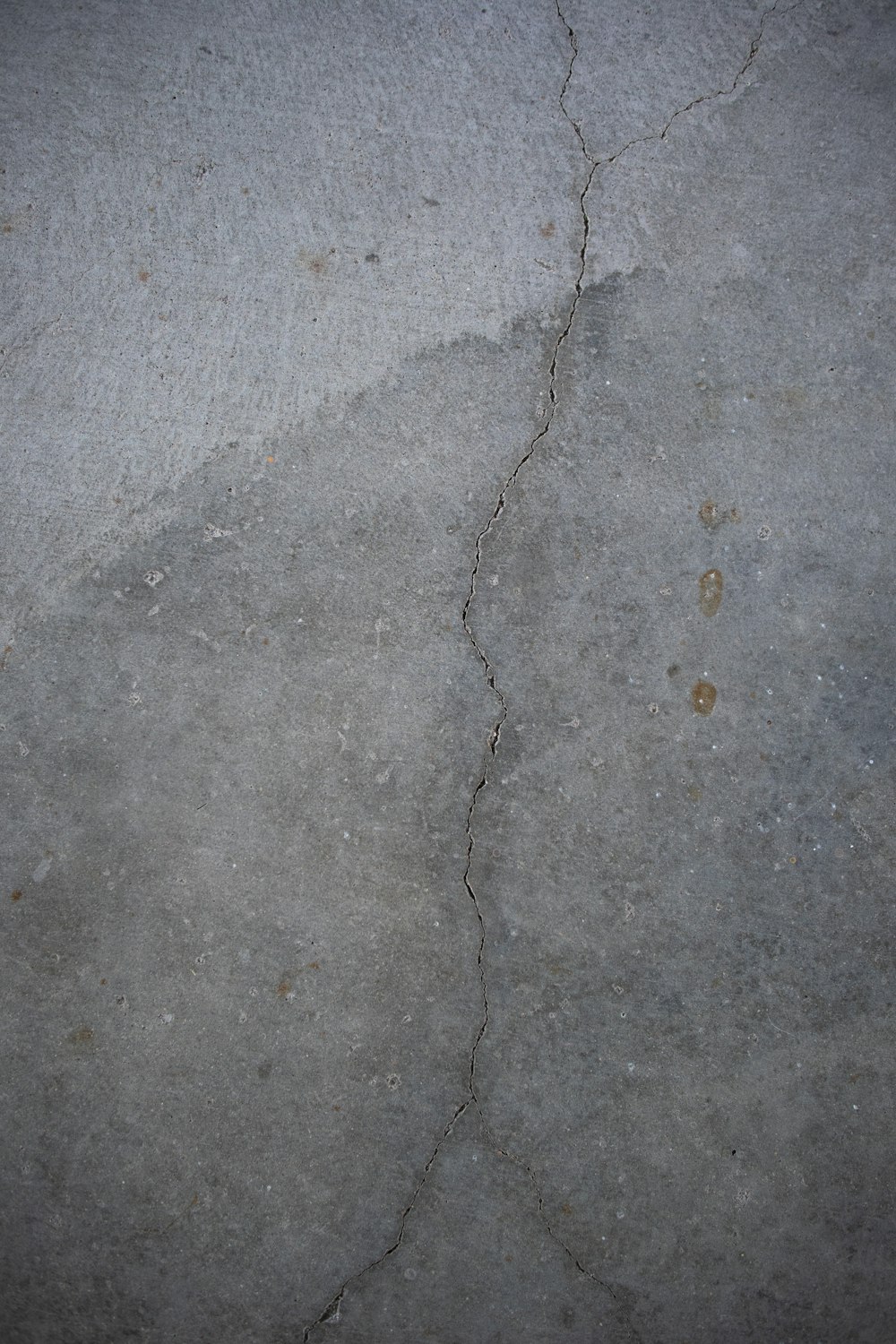 a crack in the concrete with a red fire hydrant