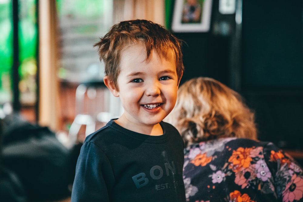a young boy smiling at the camera in a restaurant
