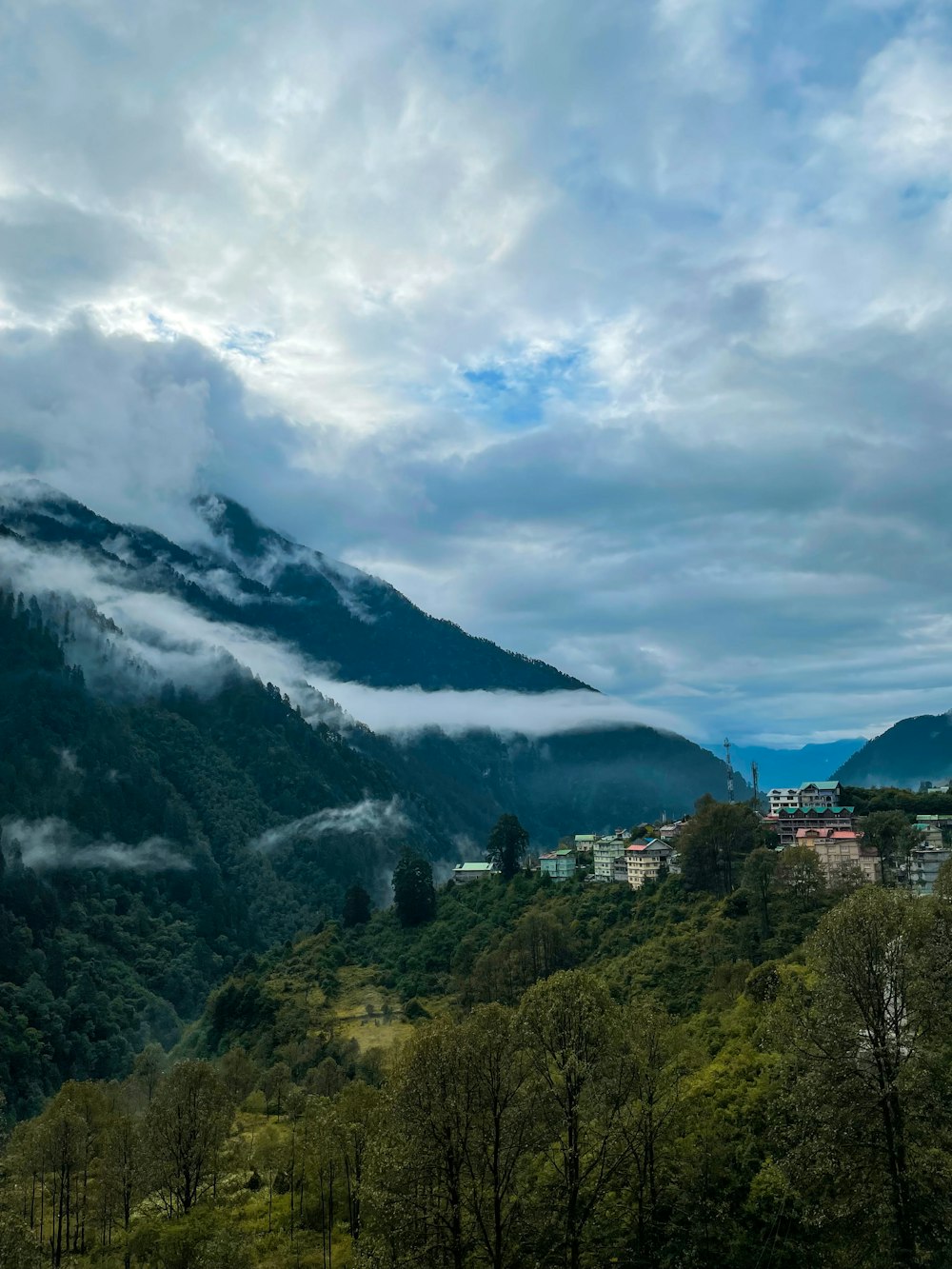 a scenic view of a town nestled in the mountains