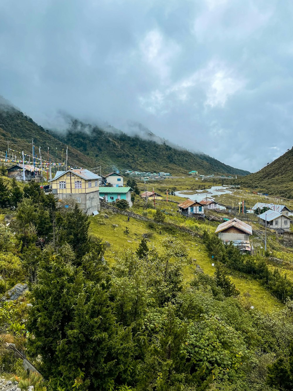 a small village in the middle of a lush green hillside