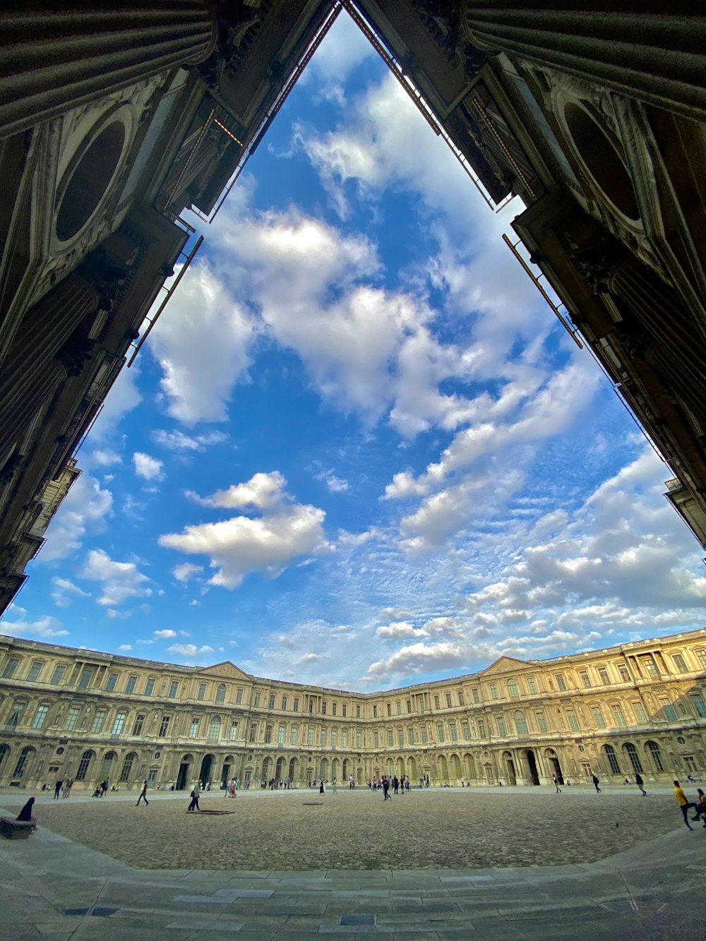 a large building with a sky filled with clouds