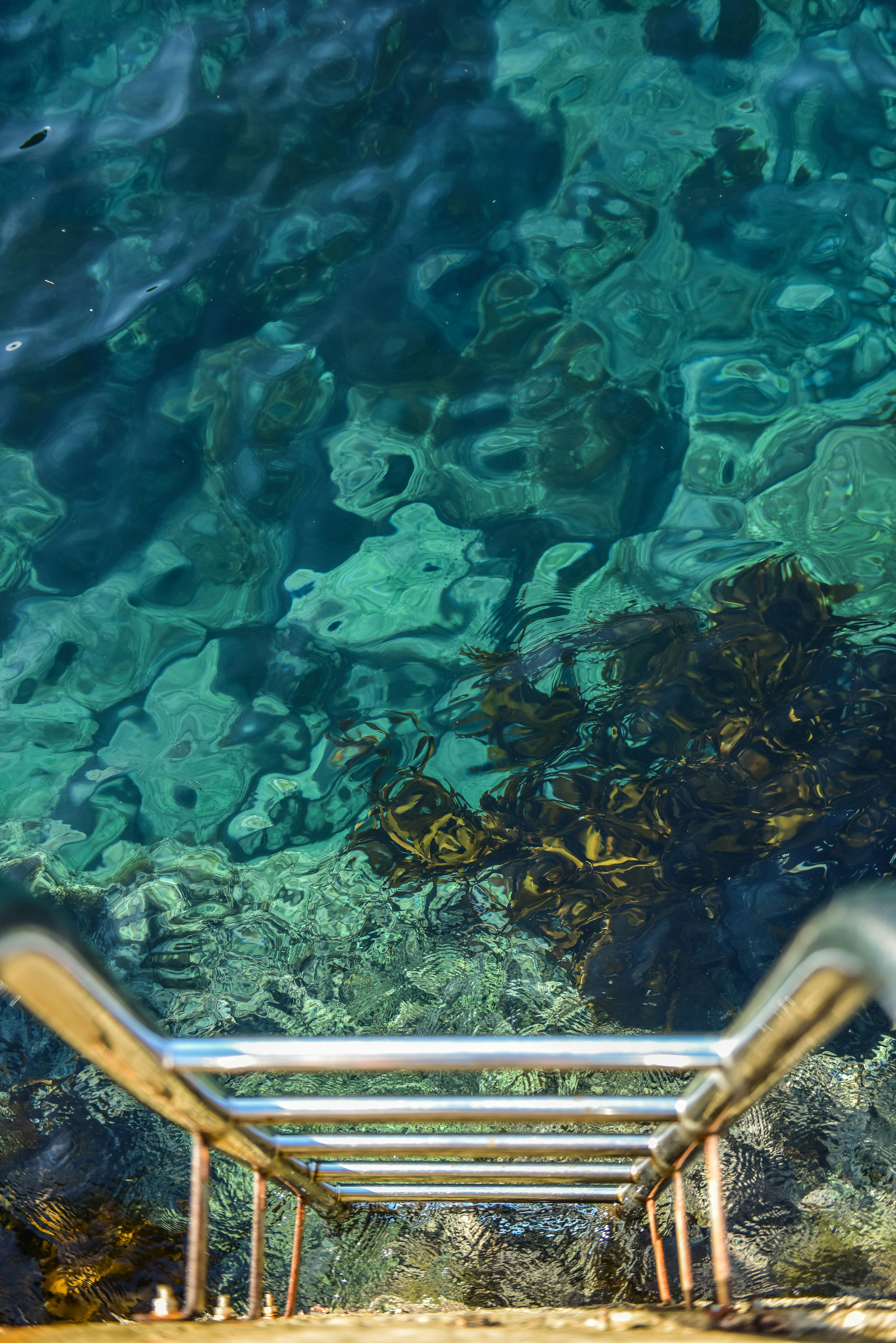 a metal bench sitting next to a body of water