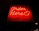 a red neon sign that says order here