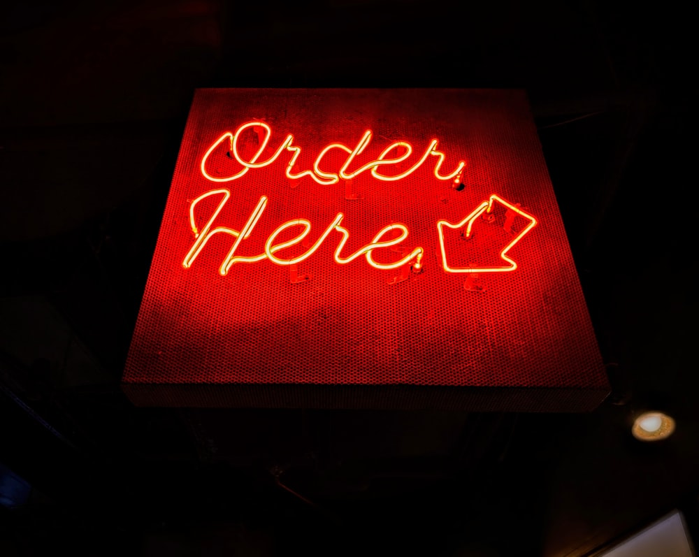 a red neon sign that says order here